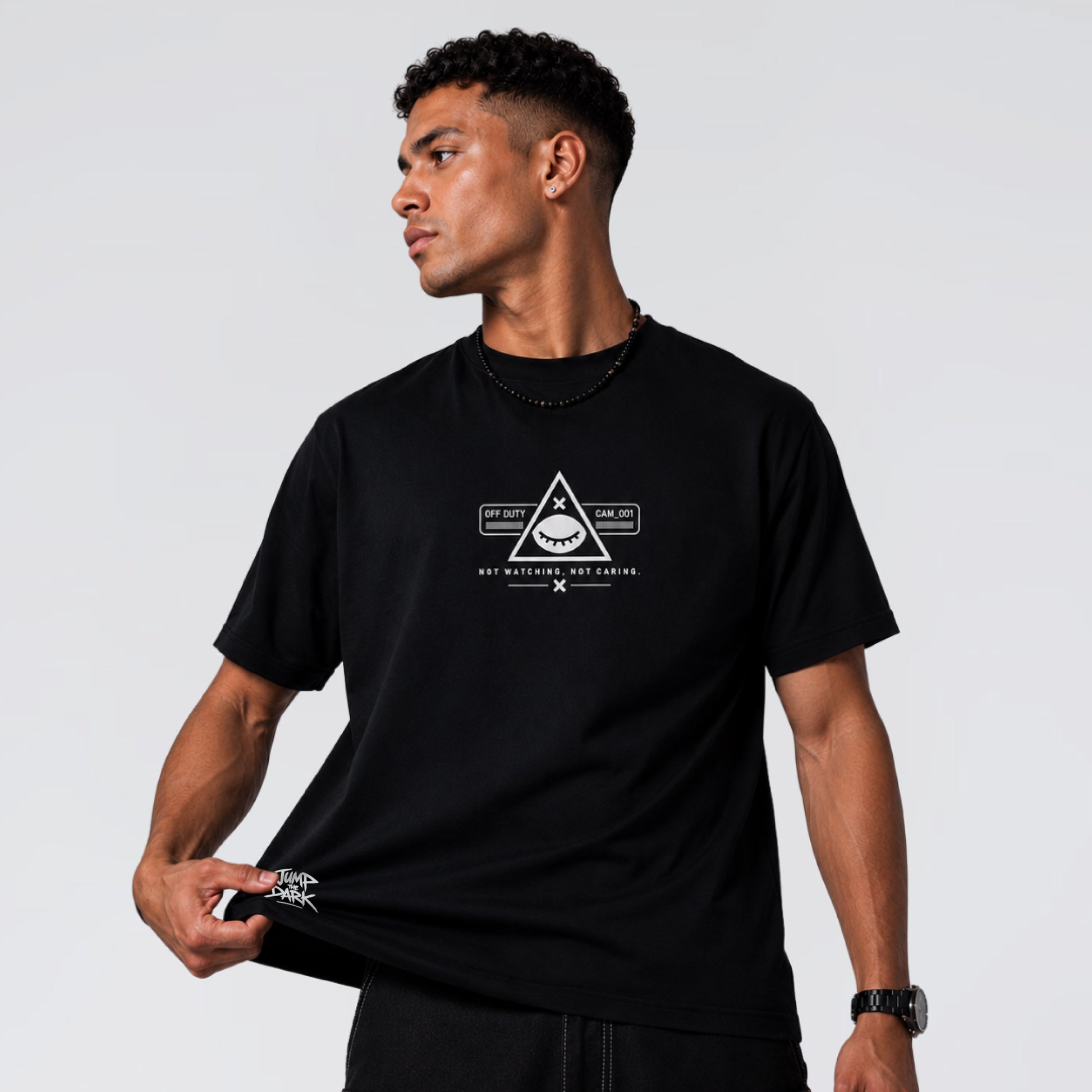Male model wearing Blind Surveillance black cotton graphic tee by Jump the Dark.