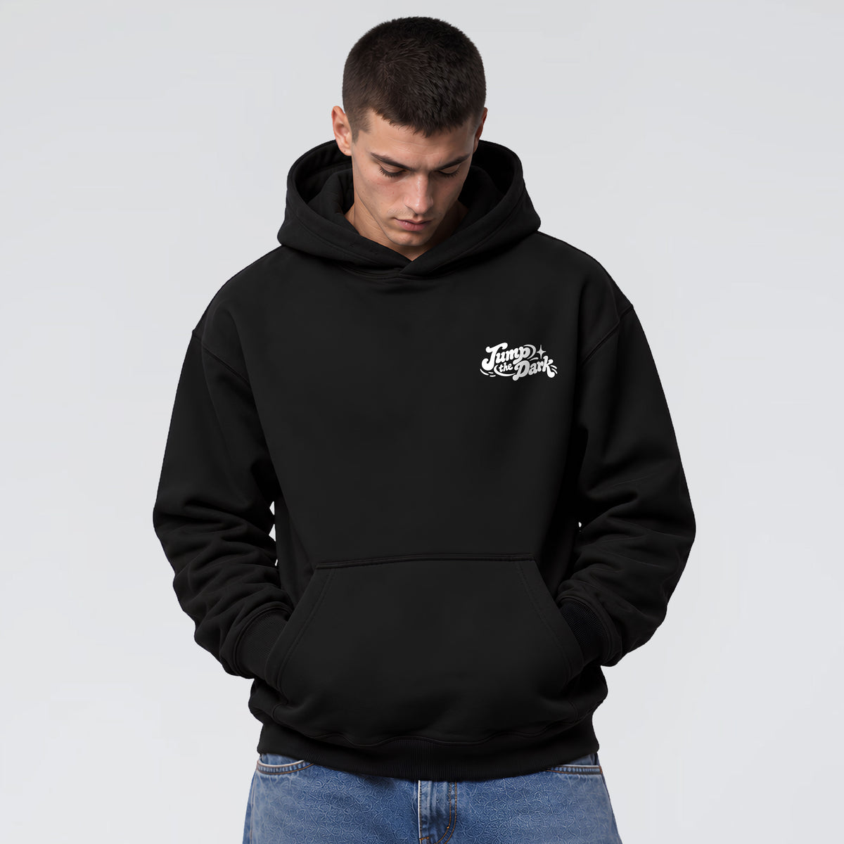 Male model wearing Keep Rolling black heavyweight hoodie with small white Jump the Dark chest logo