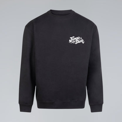 Black crewneck sweatshirt with minimal white Jump the Dark logo printed on the chest pocket.