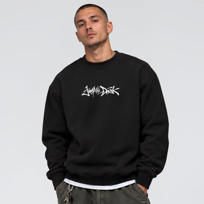 Male model wearing Signature heavyweight black crewneck sweatshirt with white Jump the Dark front graphic
