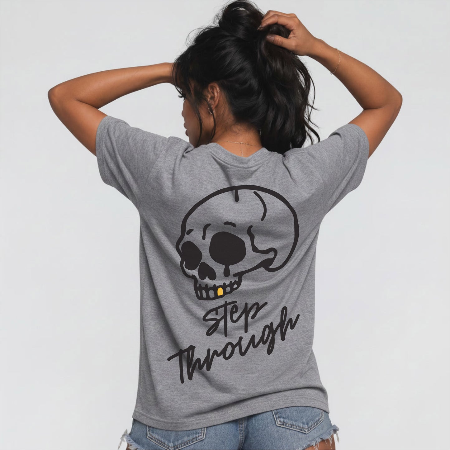 Female model wearing heather grey Jump the Dark Step Through t-shirt with large skull graphic 
