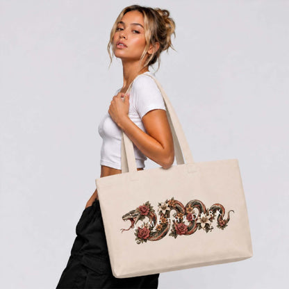 Extra-large natural canvas shoulder bag worn with detailed serpent and floral artwork