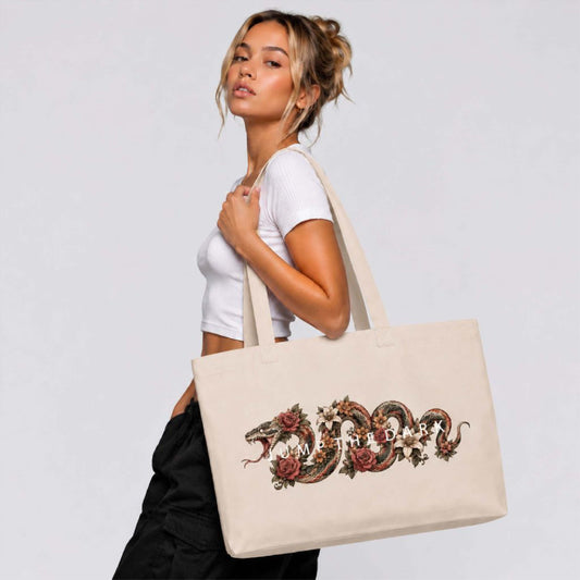 Extra-large natural canvas shoulder bag worn with detailed serpent and floral artwork